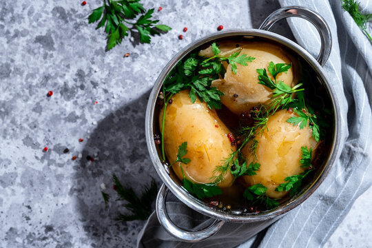 Fresh boiled potatoes in pot with aromatic herbs and black pepper