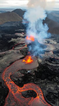 Volcanic eruption with glowing lava flow at night.