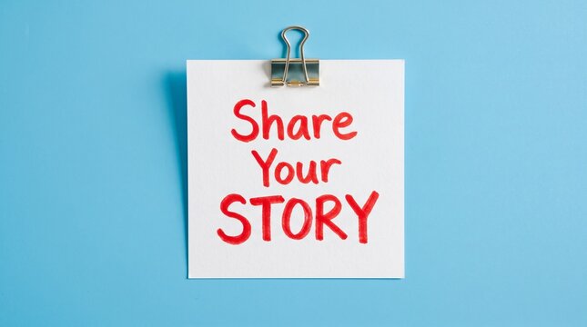 Share Your Story handwritten text on white note, inspirational message on paper with binder clip, storytelling and communication concept on blue background