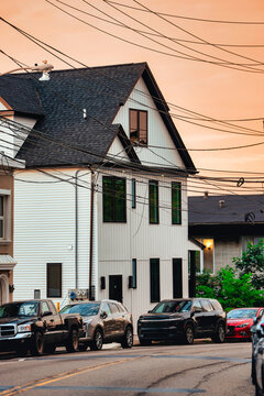 Residential Street with Modern House, Parked Cars and Overhead Utility Wires