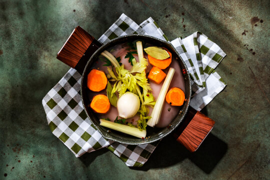 Pot of fresh chicken broth ingredients on a checkered napkin