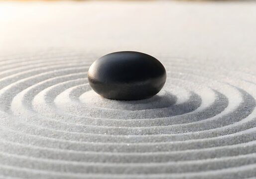 Black zen stone on white raked sand base.