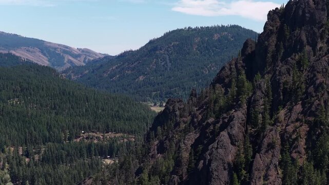 Aerial of expansive Cascade Mountains and rocky cliffs near Naches Washington in summertime