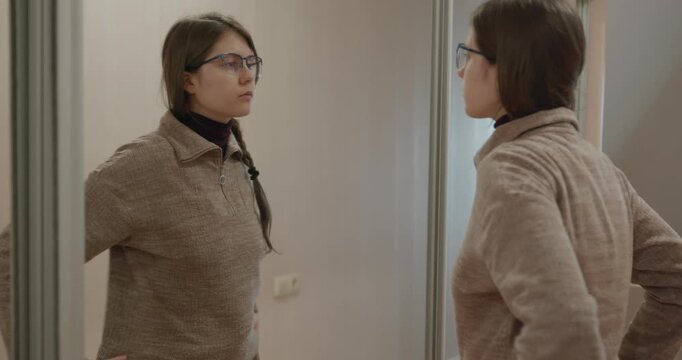 Girl Doing Hair Make Hairstyle Looking in the Mirror. 4K 10-bit