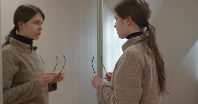 Girl Doing Hair Make Hairstyle Looking in the Mirror. 4K 10-bit