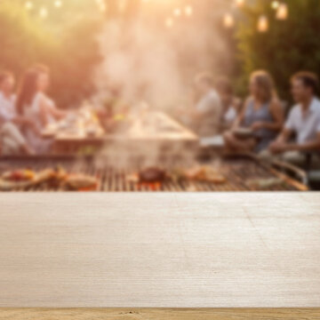 Empty wooden table for product placement. Blurred background with friends and family gathered in garden enjoying summer barbecue on sunny day. 