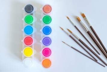 Watercolor paint set with paint brushes arranged on a white background with copy space. Art supplies, painting, creativity and artistic education concept. © Наташа Фомина
