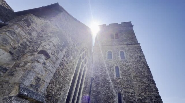 Medieval stone church tower against blue sky