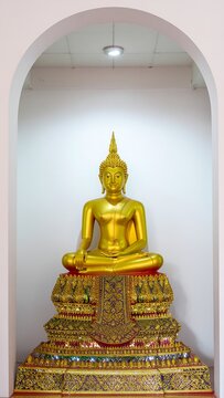 Golden Buddha statue in ornate temple setting.