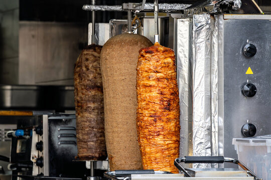 vertical rotisserie spits loaded with layers of seasoned meat for d&ouml;ner kebab