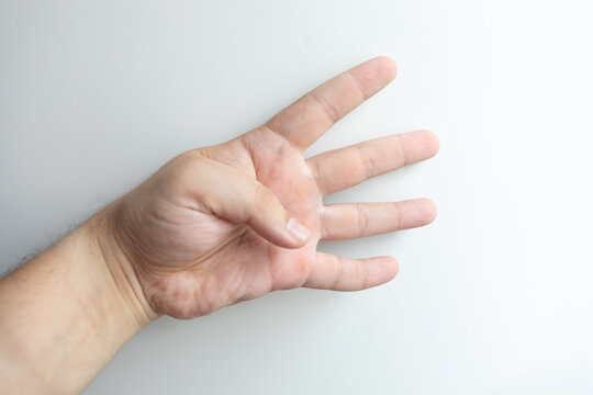 Close-up of one human hand showing four fingers against a clean white background, isolated gesture symbolizing number four, counting, communication and visual sign with copy space