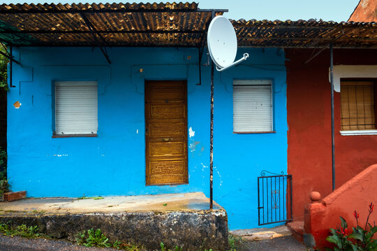 Colorful traditional rural houses on a steep street along the Camino Primitivo trail in Asturias, Spain
