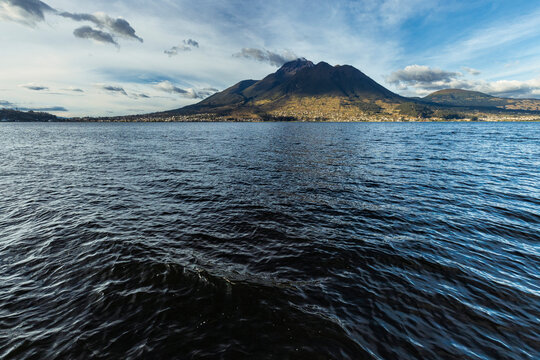 Beautiful San Pablo Lake in Otavalo, Ecuador with the majestic Imbabura Volcano in the background under a blue sky. Rural landscape of the Ecuadorian Andes