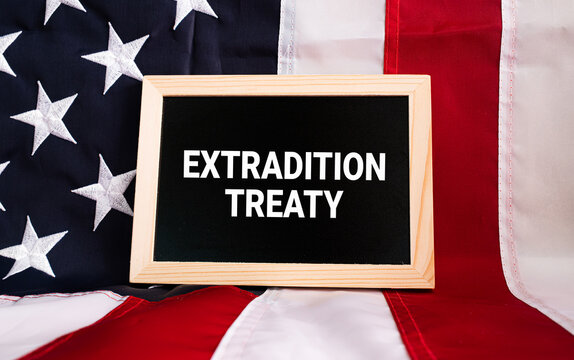 Extradition Treaty text on black chalkboard on USA flag background, international law and diplomatic relations concept
