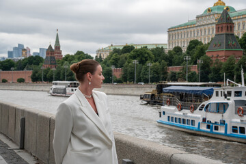 Profile portrait of woman on Sofiyskaya Embankment overlooking Kremlin and river boats in Moscow. Urban lifestyle, travel, architecture, sightseeing, confidence, cityscape, tourism © Sofia