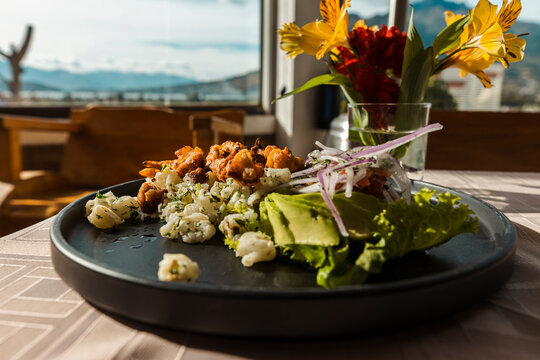 Gourmet presentation of traditional mote with crispy pork chicharron, avocado, and fresh onions