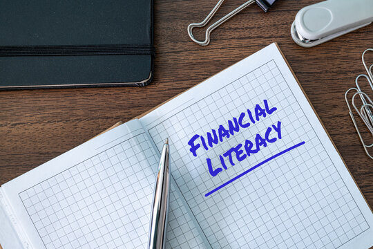 Financial Literacy text written on notebook with pen and office supplies on desk, personal finance and education concept