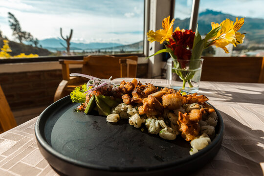Gourmet presentation of traditional mote with crispy pork chicharron, avocado, and fresh onions