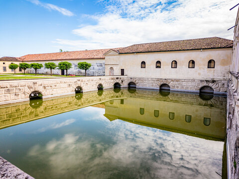Palazzo Te's historic Renaissance architecture reflecting in the calm waters of the Giardino Grande pool on a clear day, showcasing cultural heritage and classic Italian design in Mantua, Lombardy