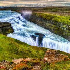 powerful waterfall cascading over rugged cliffs © dchumak