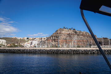 Fototapeta premium The town of San Sebastian de La Gomera and its dramatic cliff seen from a boat leaving the marina Canary Islands
