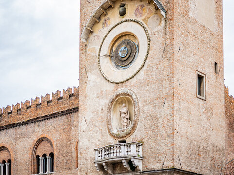 Torre dell'Orologio, a historic clock tower with an astronomical dial, facade sculpture, and small balcony, representing Italian Renaissance architecture in Mantova