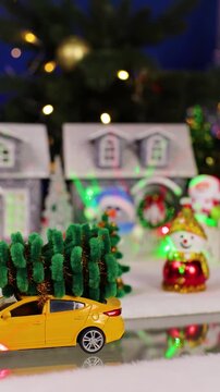 A yellow car drives past the Christmas town