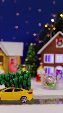 A yellow car drives past the houses and snowmen