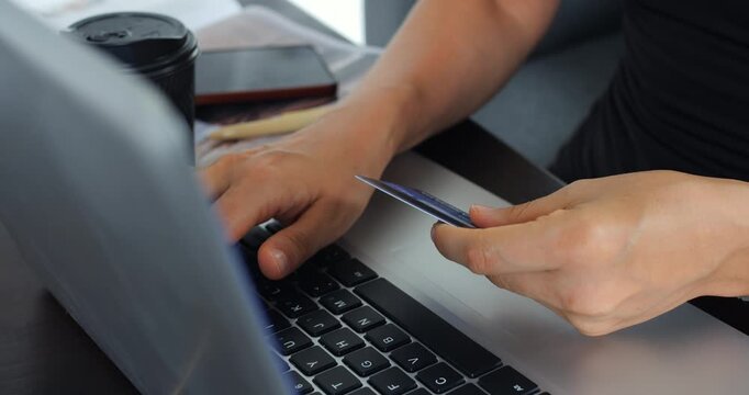 Focused work scene. Person verifying bill with laptop. Individual handling documents and digital payment processing. Someone reviewing bills and utilizing computer with coffee close by