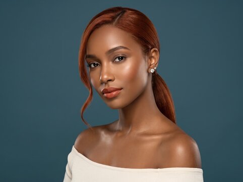 Fiery red hair contrasts a deep teal backdrop