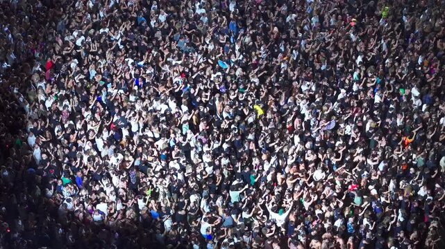 High angle aerial view of massive crowd dancing at live music festival concert