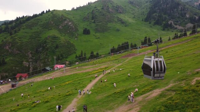 funicular traveling in the mountains. Drone footage flying alongside the funicular against a mountain backdrop.