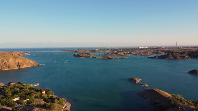 Video of a lake with small islands and ships. Drone footage of a lake featuring beautiful ships and lovely lighting.