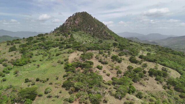 A mountain landscape with trees and hills. Clear sky and green vegetation.
