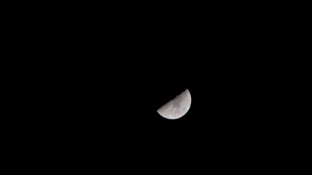 view of the half moon phase in the dark night sky