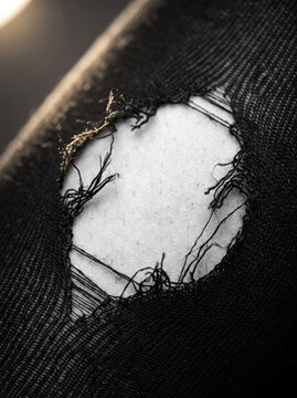 Macro Photograph of Ripped Hole in Black Denim Jeans Fabric