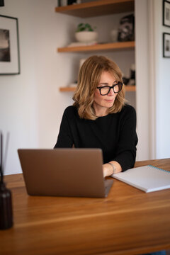 Mature adult woman remote working on laptop at home