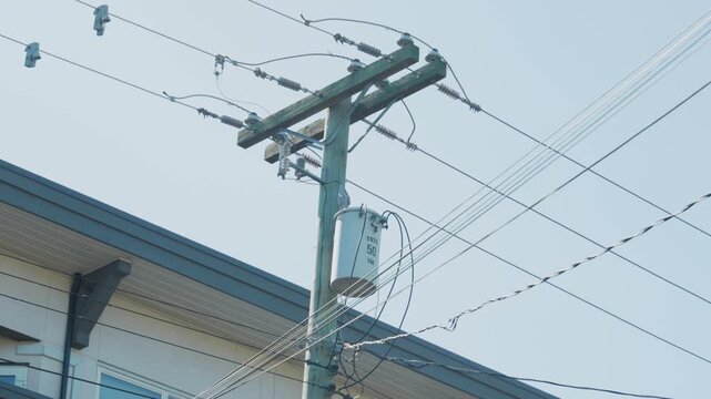 Utility pole transformer with electrical power lines on street