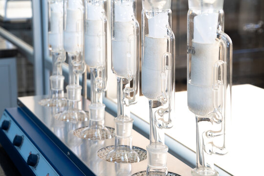 Fila de condensadores de destilaci&oacute;n de vidrio en un laboratorio qu&iacute;mico profesional