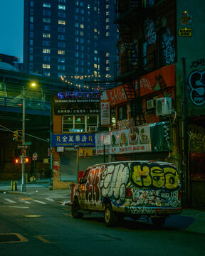Graffiti-covered van on Division Street at night in Chinatown, Manhattan, New York City