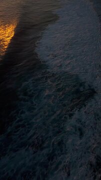 Vertical video. Fast FPV Drone Dive Above Karang Boma Cliff During Golden Sunset, First Person Flight Following Ocean Surf Along Dramatic Coastal Cliffs, Adventure And Exploration