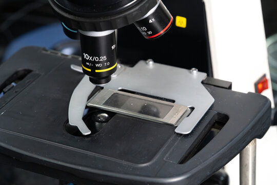 Platina de microscopio y lente objetivo en laboratorio