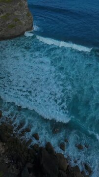 Vertical video. Extreme FPV Drone Dive Down Mercusuar Lighthouse Cliffs Above Powerful Ocean Waves And Rugged Tropical Coastline, Adrenaline Freedom Speed And Aerial Exploration in Bali