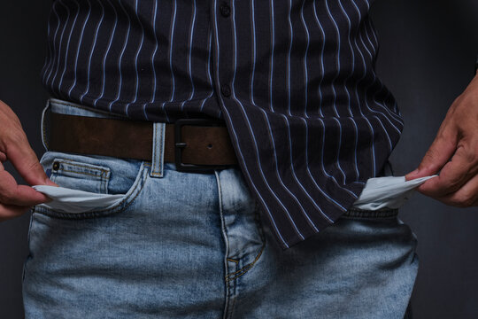 Man turning his empty pockets inside out, financial crisis, bankruptcy, or poor concept closeup.