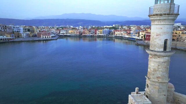  View of Chania with the amazing lighthouse, mosque, venetian shipyards, Crete, Greece.Waves crashing on lighthouse, Beautiful Greece and best scenic places - panorama