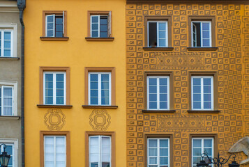Obraz premium Close up of a yellow facade with windows and ornaments, buildings on the Castel square, Warsaw, Poland