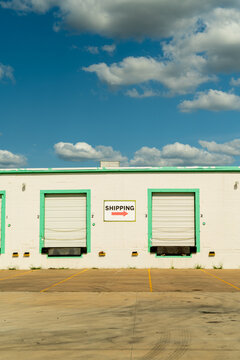 Industrial Shipping and Receiving Truck Dock Garages of Industrial Factory Building With Shipping Sign With Cloudy Blue Sky