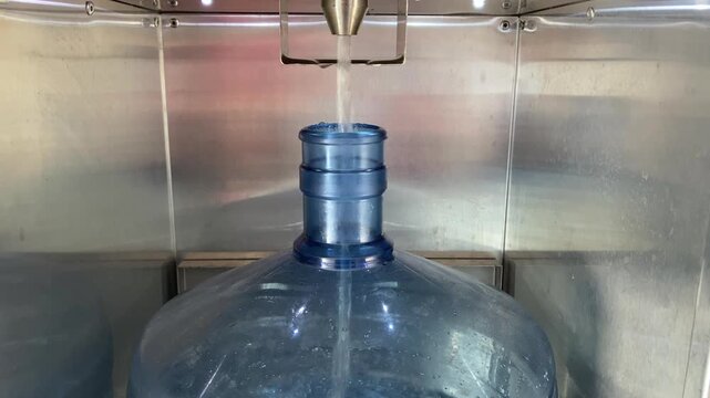 Large reusable jug filling with purified consumable product from a self service machine promoting eco friendly choices.
