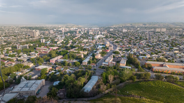 From a high vantage point, the stunning landscape of Osh unfolds. Lush greenery meets urban life, creating a vibrant scene. Sulaiman-Too stands tall, rich in history and culture.