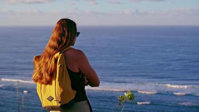 Young Female Traveler Watching Ocean Waves From Coastal Cliff During Golden Hour, Relaxation, Mindfulness And Scenic Travel Experience
